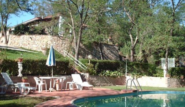 Detached cottage in a park-like garden overlooking the pool